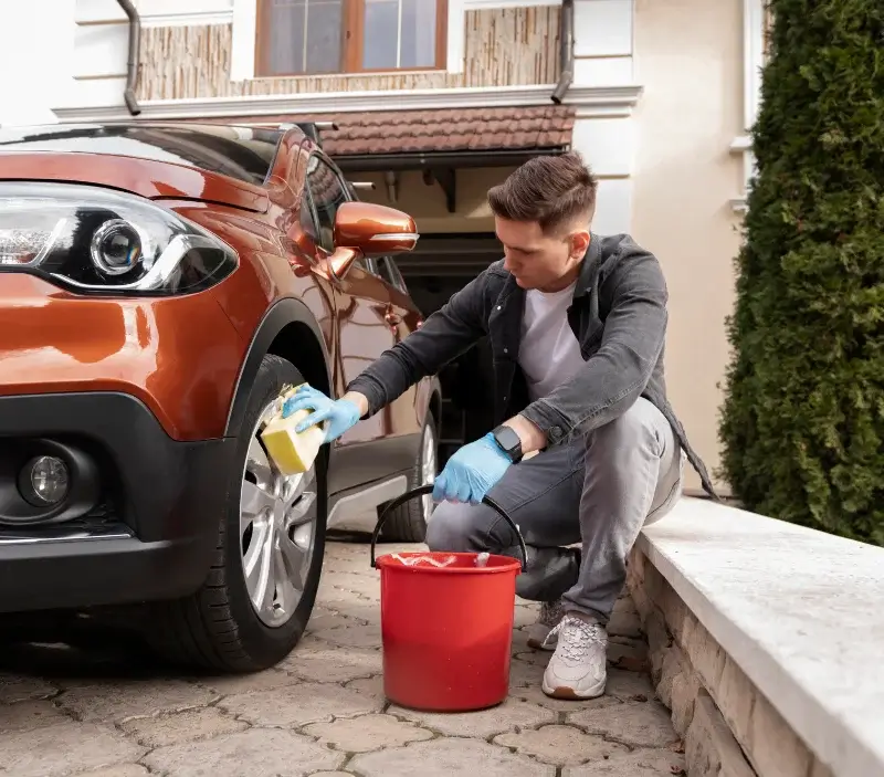 Lavage auto à domicile Saint-Just-Sauvage : professionnel intervenant sur un véhicule